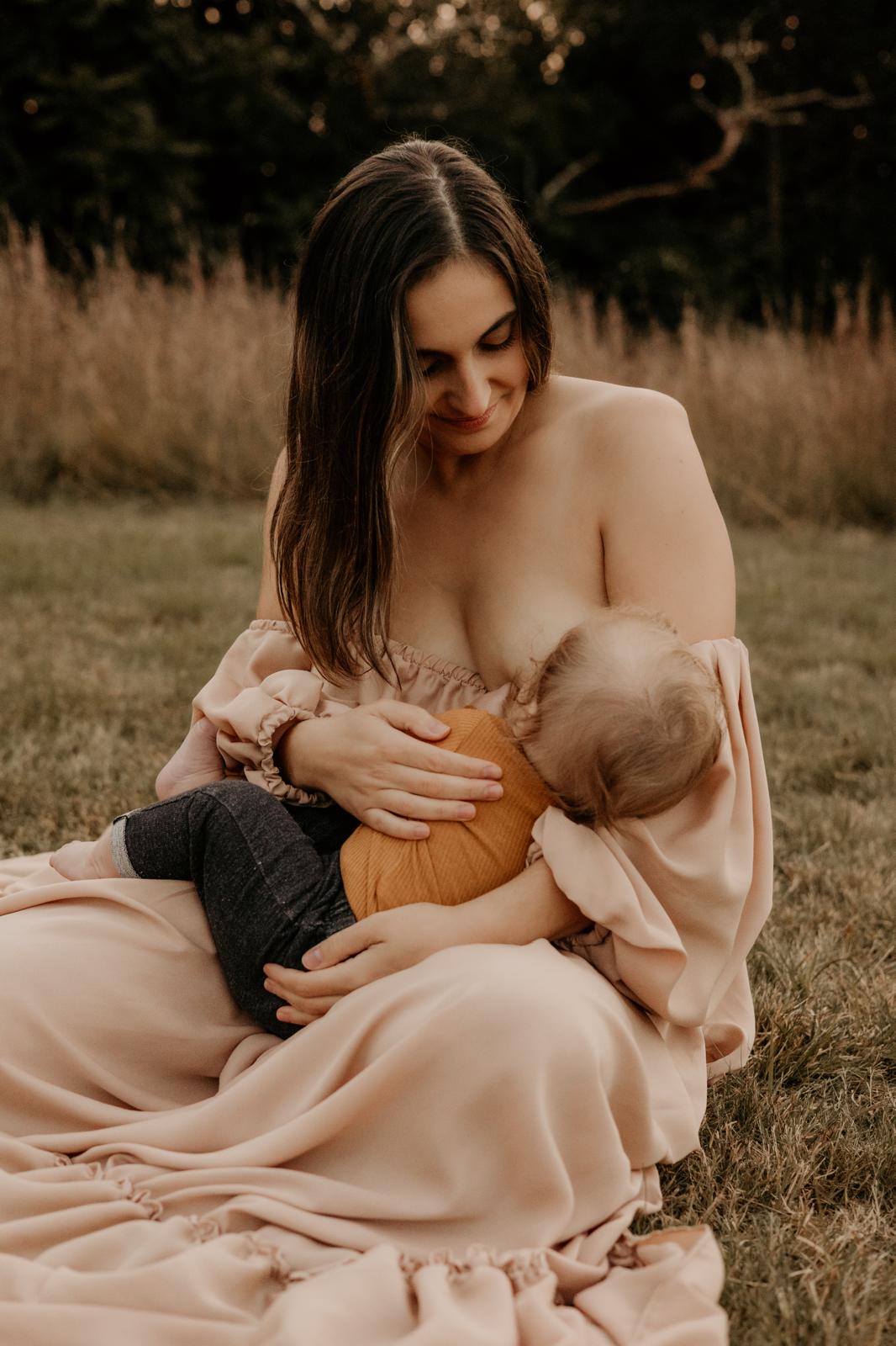 Bruna Gomes breastfeeding her youngest child in a golden field