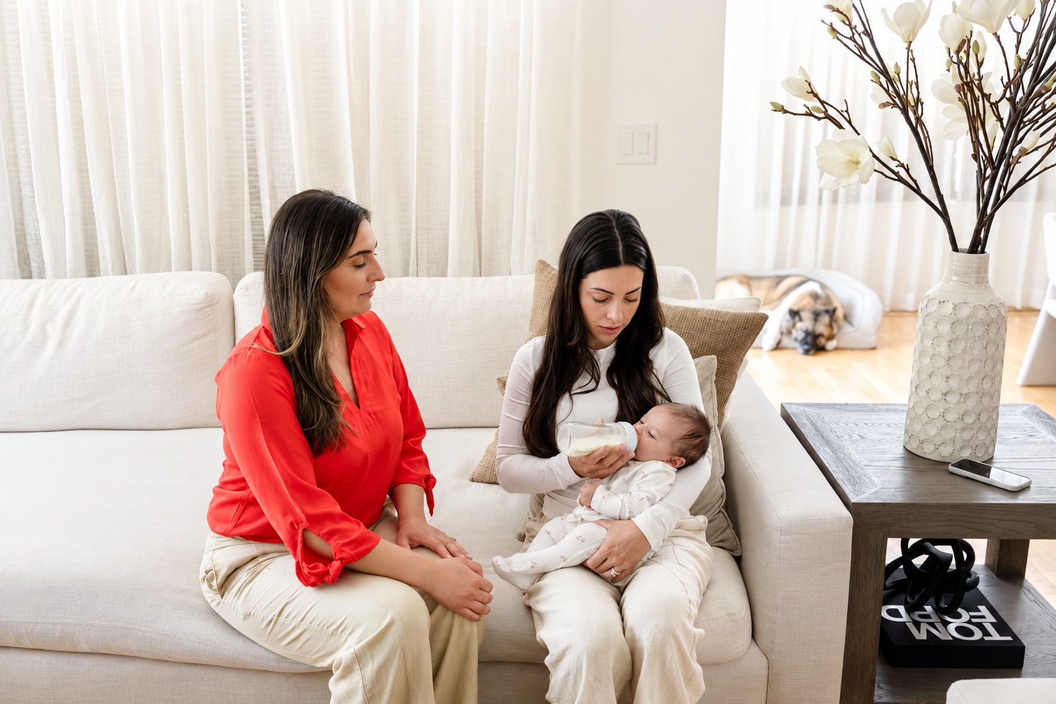 Bruna on the sofa with a mother and her newborn
