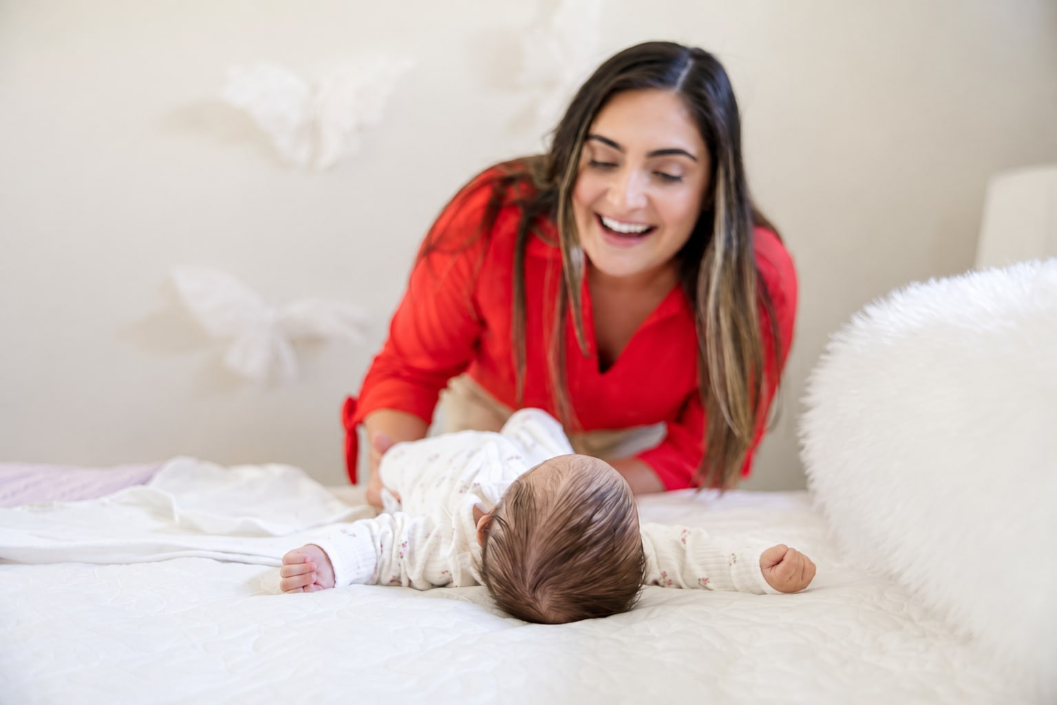 Bruna beside a newborn lying in soft light